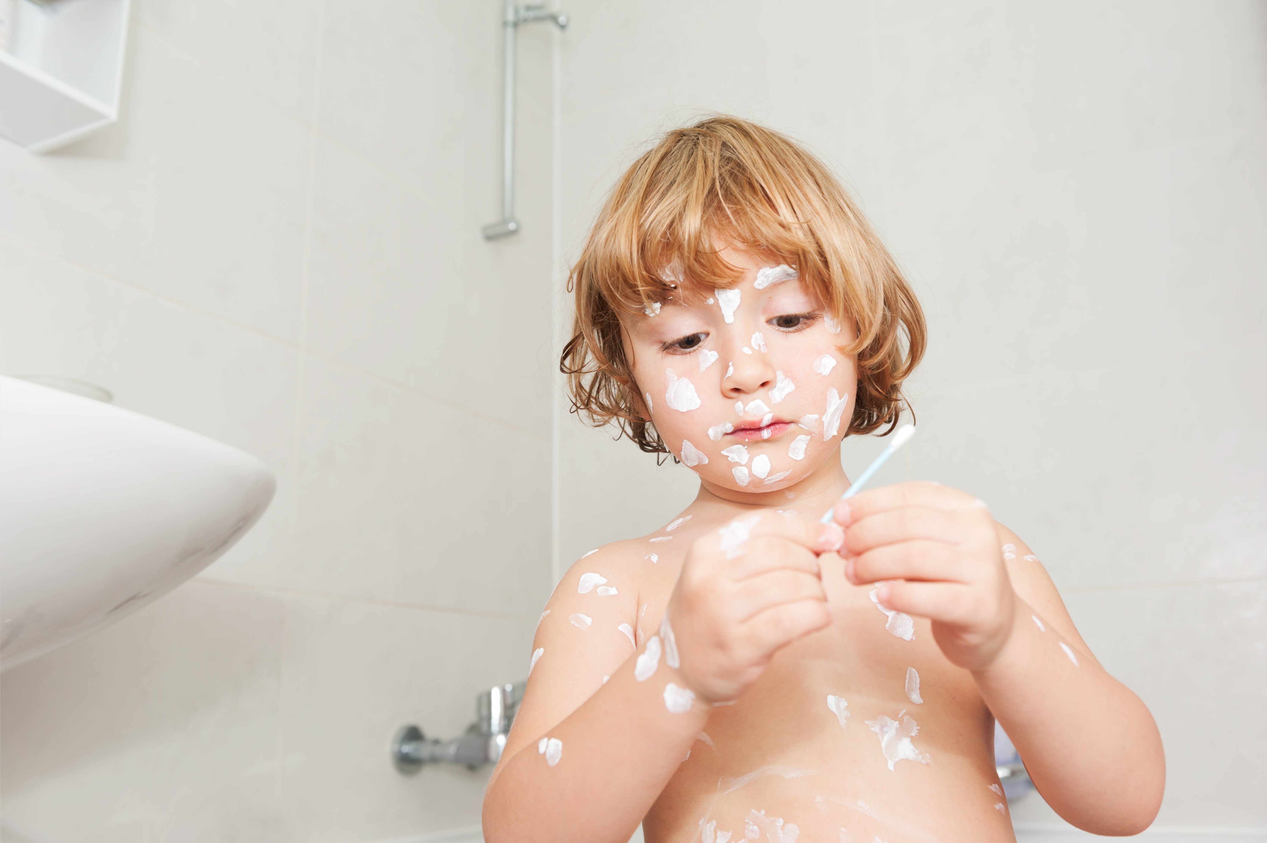 Little boy puts too much body lotion on her