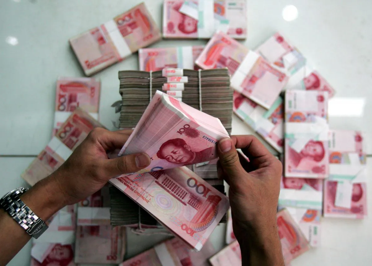 A clerk counts stacks of Chinese yuan at a bank in Beijing, China, on July 22, 2005. (China Photos/Getty Images)