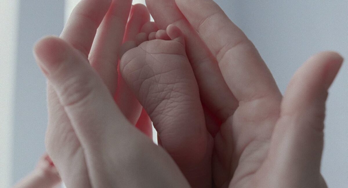 mother's hands and baby foot in "The Tree of Life"