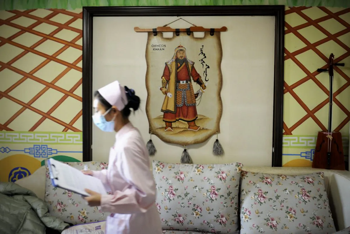 A nurse walks past a portrait of Genghis Khan, founder and Great Khan of the Mongol Empire, in a maternity ward at Antai Hospital in Beijing, China, on Nov. 28, 2012. (Wang Zhao/AFP/Getty Images)
