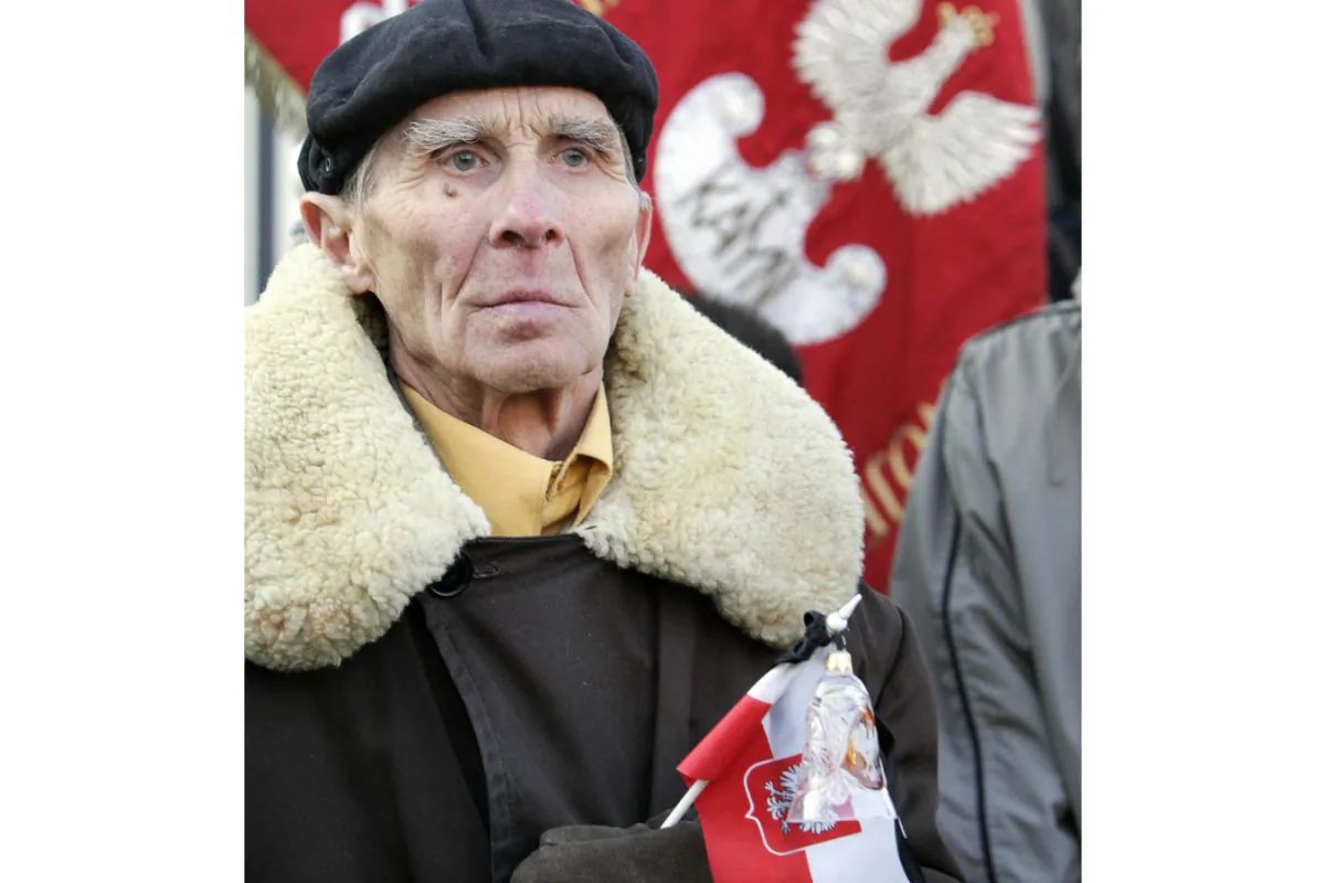 An elderly man holding a Polish nation flag during a demonstration in front of Russia's embassy in Warsaw on March 15, 2005, against the decision of Russia's chief military prosecutor to stop the investigation into the 1940 Katyn Forest massacre, in which the Soviets summarily execute over 20,000 Poles. (Janek Skarzynski/AFP/Getty Images)