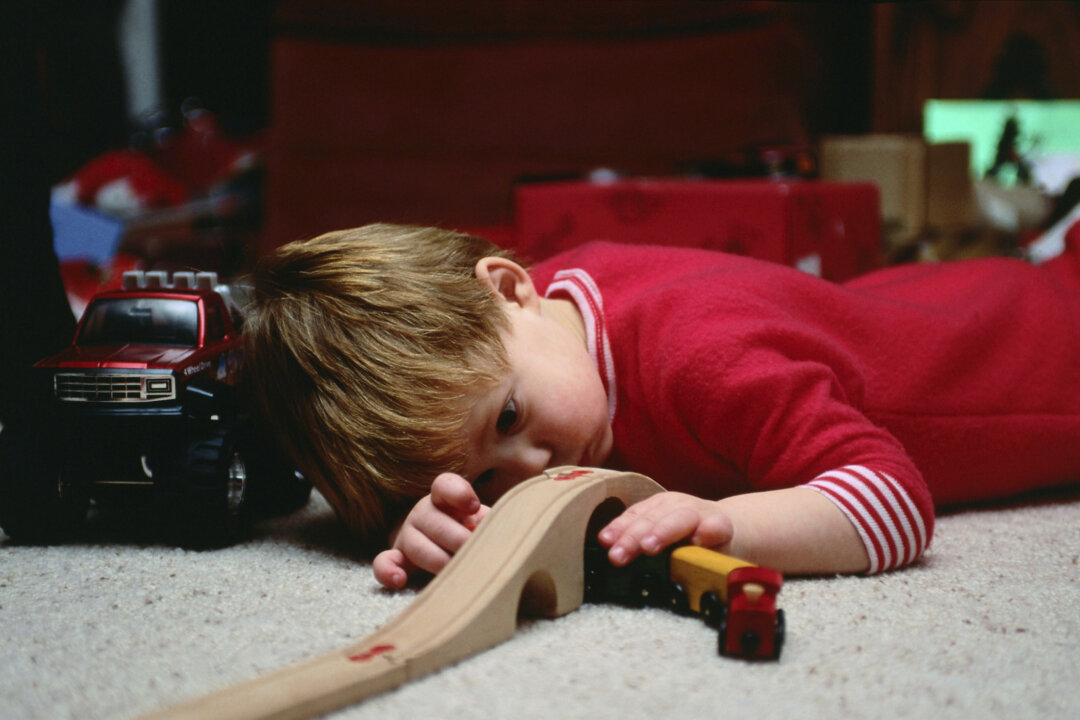 A young boy plays quietly and intently with his wooden train set. When choosing gifts for children this holiday season, consider toys that are fun as well as spark children’s creativity, and be vigilant about product safety. (Ablestock.com/Photos.com)