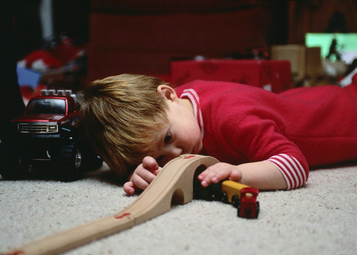 A young boy plays quietly and intently with his wooden train set. When choosing gifts for children this holiday season, consider toys that are fun as well as spark children’s creativity, and be vigilant about product safety. (Ablestock.com/Photos.com)