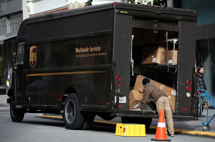 A UPS worker unloads packages from his truck on Dec. 20, 2012 in San Francisco, Calif. (Photo by Justin Sullivan/Getty Images)