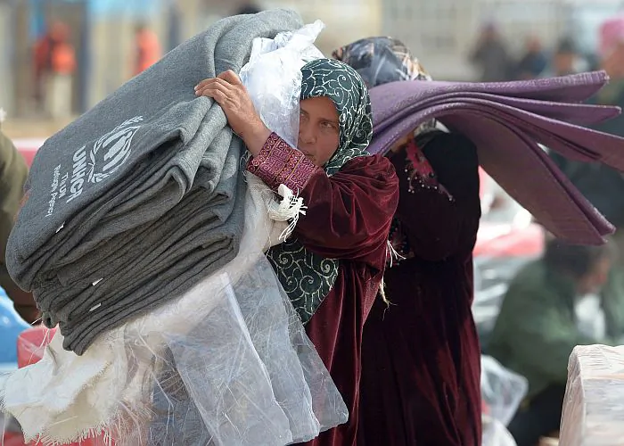 Refugees from Syria collect blankets and supplies from the UNHCR as they arrive at the Za’atari refugee camp on Jan. 30, 2013, in Mafrq, Jordan. Record numbers of refugees are fleeing the violence and bombings in Syria to cross the borders to safety in northern Jordan and overwhelming the Za'atari camp. (Jeff J Mitchell/Getty Images)