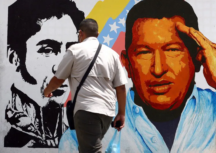 A man walks past a mural portraying the Venezuelan flag, President Hugo Chavez and South American liberator Simon Bolivar at the 23 de Enero neighbourhood, in Caracas on March 5, 2013. Chavez died on Tuesday at age 58. (Geraldo Caso/AFP/Getty Images)