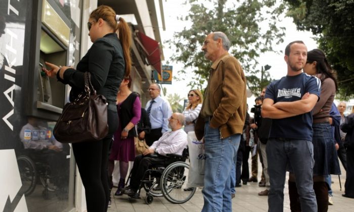 People wait in line to withdraw money from an ATM of a Laiki Bank branch in Cyprus's capital, Nicosia, on March 21, 2013. Financial turmoil in Cyprus has left its mark on daily life—from closed shops, to flaring tempers in ATM lines, to peaceful protests. (Patrick Baz/AFP/Getty Images)