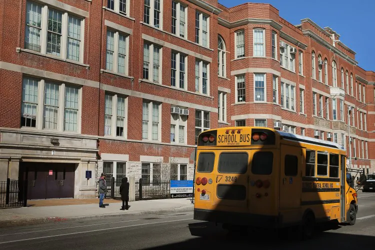 A school bus drives by the Jean De Lafayette Elementary School on March 21, 2013 in Chicago, Illinois. The school is one of 50 schools slated to be closed by the city. (Scott Olson/Getty Images)