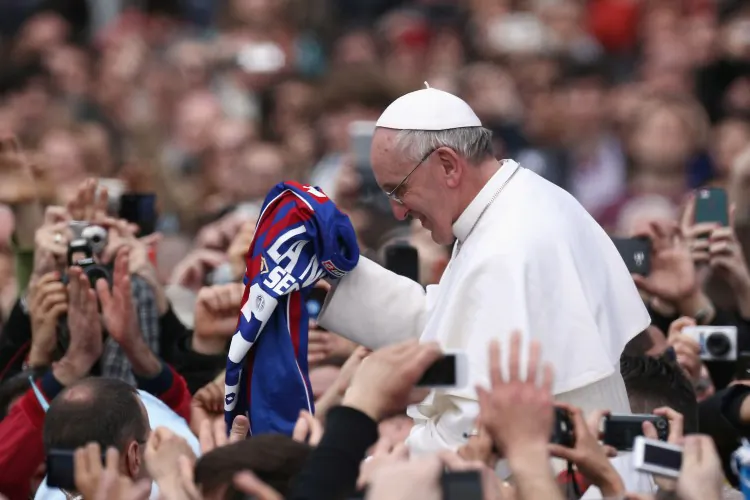Pope Francis is given a San Lorenzo's shirt, the Buenos Aires football team as he greets the faithful prior to his first 'Urbi et Orbi' blessing from the balcony of St. Peter's Basilica during Easter Mass on March 31, 2013 in Vatican City, Vatican. (Photo by Dan Kitwood/Getty Images)