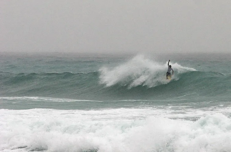 A woman was killed by a giant wave in Cabo San Lucas on Wednesday. Pictured above, a tourist surfs waves in Cabo San Lucas in September 2006. (Luis Acosta/AFP/Getty Images)