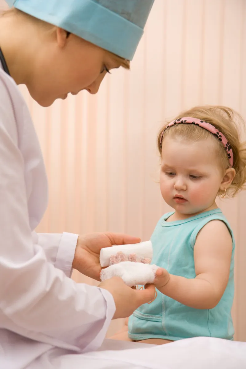 A paediatrician puts a bandage on a little girl's hand. A new study says front-line physicians can do much to improve health equity by taking practical steps to help their patients counter social or economic factors that act as barriers to good health. (Vadim Ponomarenko/Fotolia)