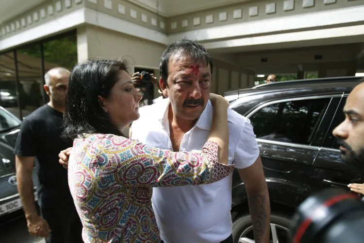 Sister Priya Dutt, tries to console Indian Bollywood actor Sanjay Dutt, center, after he broke down during a press conference at his residence in Mumbai, India, Thursday, March 28, 2013. Dutt says he has not sought pardon for a 1993 weapons conviction and will serve his prison sentence as ordered by India's Supreme Court. (AP Photo/Rafiq Maqbool)