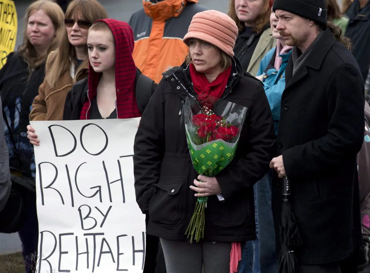 Leah Parsons, mother of Rehtaeh Parsons, and her partner Jason Barnes (R), attend a protest near the Halifax Regional Police headquarters in Halifax on April 14, 2013. Rehtaeh Parsons ended her own life following months of bullying after she was allegedly sexually assaulted by four boys and a photo of the incident was distributed online. (The Canadian Press/Andrew Vaughan)