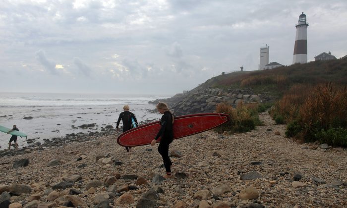 Surfers head out to the water at the Montauk lighthouse in this 2010 file photo in Montauk, New York. Governor Andrew Cuomo announced all beaches and State Parks will be open in time for the Memorial Day opening. (Spencer Platt/Getty Images)