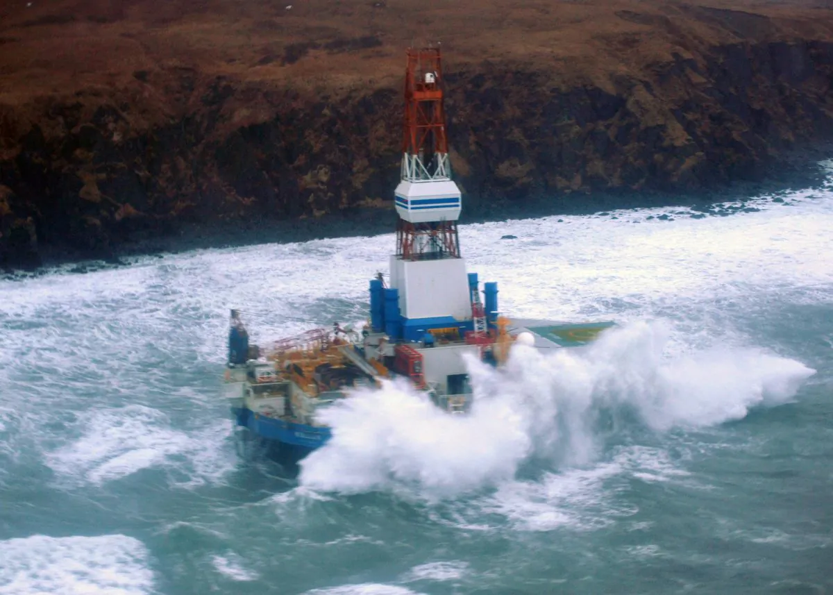 Waves crash over the Shell drilling unit the Kulluk as it sits aground on an island south of Anchorage. (U.S. COAST GUARD PETTY OFFICER 3rd CLASS JONATHAN KLINGENBERG)