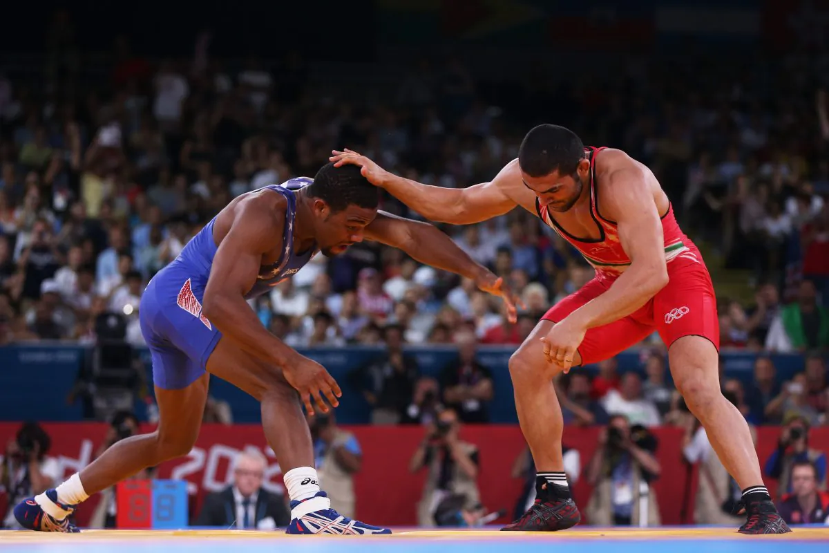 Jordan Ernest Burroughs of the United States (blue) competes with Sadegh Saeed Goudarzi of Islamic Republic of Iran at the 2012 Olympic Games in London. The U.S., Iran, and Russia will wrestle in New York City in May. (Feng Li/Getty Images)