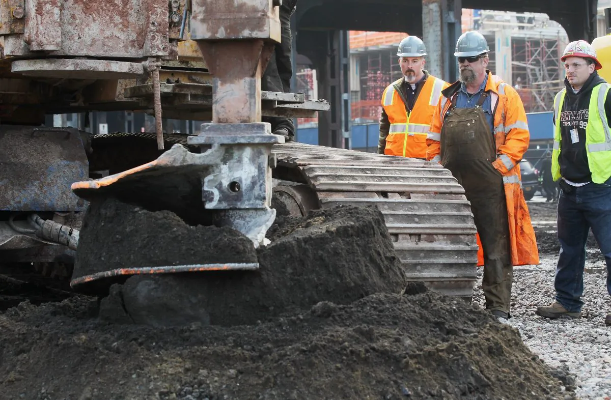 Workers watch as ground is broken at a groundbreaking ceremony for the Hudson Yards development at the site which is expected to boast 13 million square feet of residential and commercial space on a 26-acre site on Manhattan’s west side on December 4, 2012 in New York City. The site was the largest undeveloped piece of property in Manhattan and is expected to create around 23,000 construction jobs. It will be the largest private development in the city since Rockefeller Center. (Photo by Mario Tama/Getty Images)