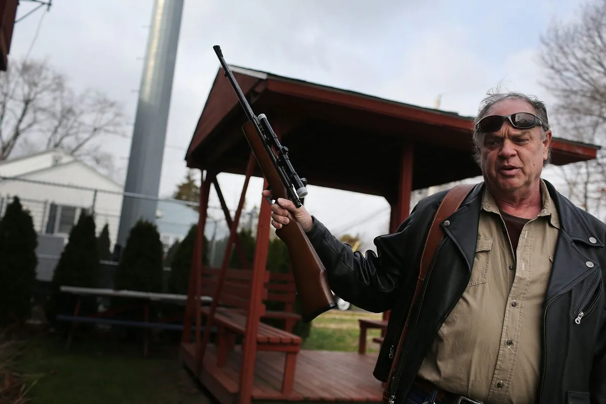 Holding one of three rifles he's turning in, Bob Coyle stands outside of a gun buyback event in Bridgeport, Conn. A gun manufacturer based in the state says its moving because of new gun control laws that are too strict. (Spencer Platt/Getty Images)