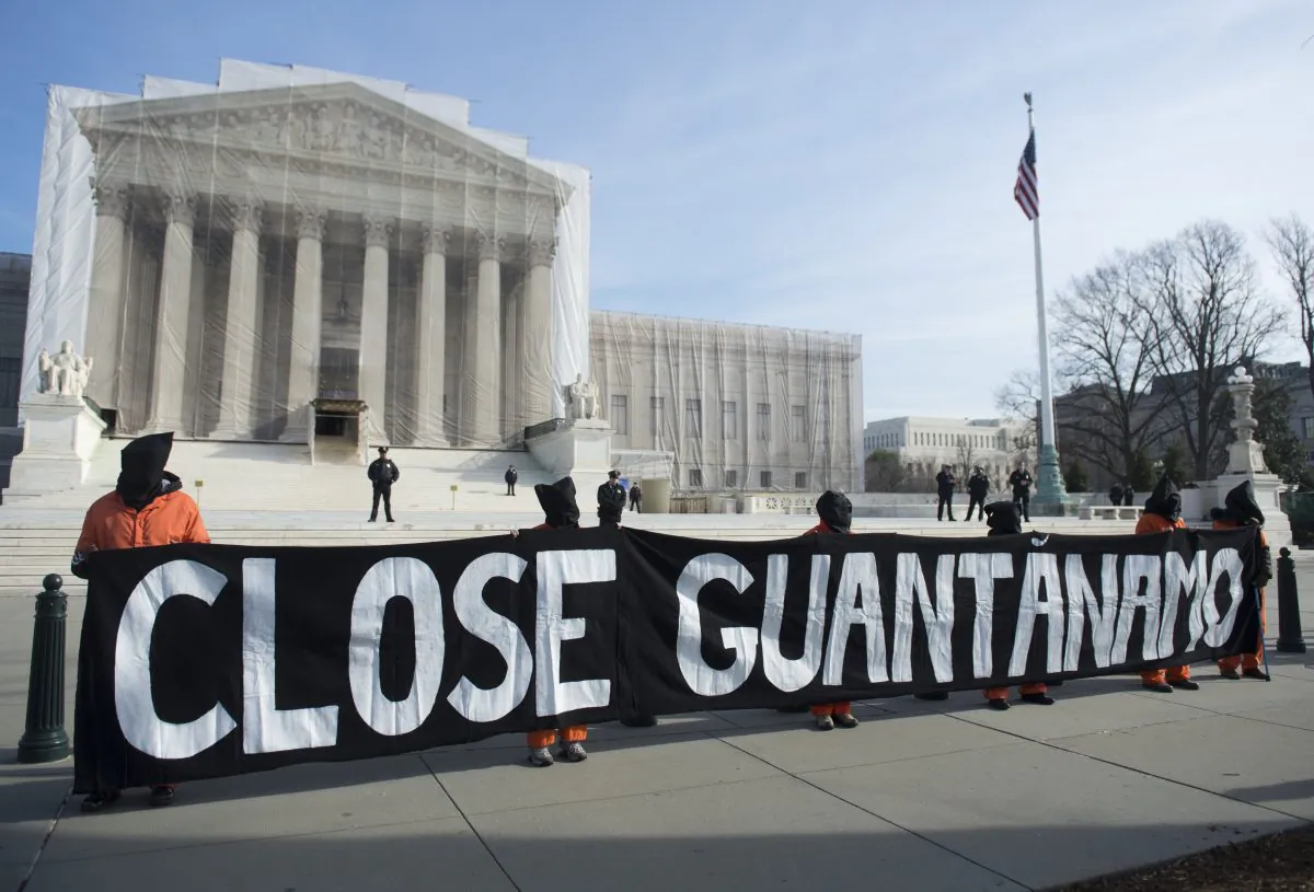 Protesters wear orange prison jump suits and black hoods on their heads as they protest against holding detainees at the military prison in Guantanamo Bay on Jan 8, 2013 in Washington D.C. (SAUL LOEB/AFP/Getty Images)
