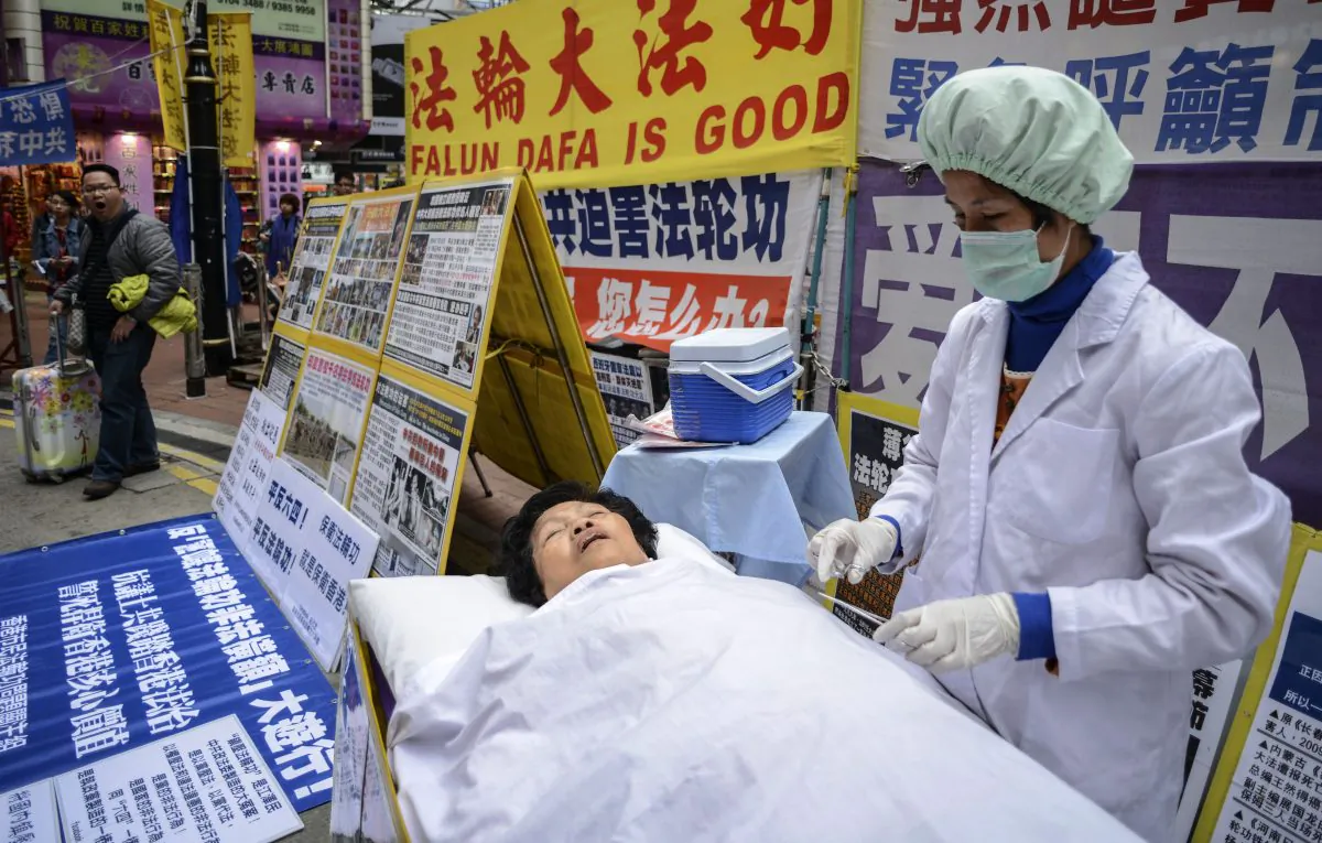 Falun Gong members perform a mock forced organ removal in a shopping district of Hong Kong on Jan. 12, 2013. (Antony Dickson/AFP/Getty Images)
