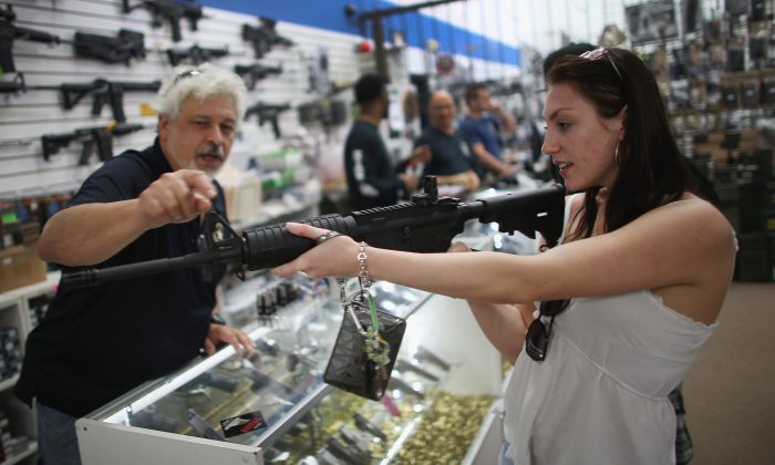 As the U.S. Senate takes up gun legislation in Washington, D.C., Dr. Gary Lampert (L), a co-owner of the National Armory gun store, helps Cristiana Verro consider fire arms in Pompano Beach, Fla., on April 11, 2013. (Joe Raedle/Getty Images)