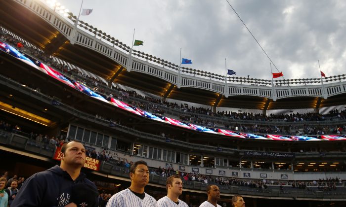 Joba Chamberlain and the rest of the New York Yankees observes a moment of silence to honor the victims of the Boston Marathon bombing on April 16, 2013 at Yankee Stadium in the Bronx borough of New York City. (Elsa/Getty Images)