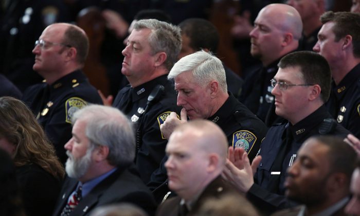Boston police officers and EMTs listen as Barack Obama speaks at an interfaith prayer service for victims of the Boston Marathon attack titled 'Healing Our City,' at the Cathedral of the Holy Cross on April 18, in Boston, Mass. (Photo by Spencer Platt/Getty Images)
