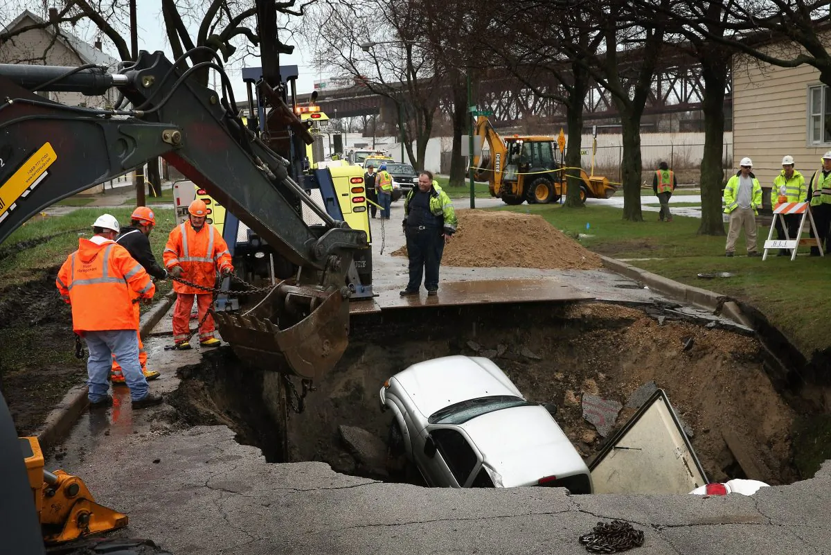 Workers prepare to pull a truck from a sinkhole that opened up on a residential street in the South Deering neighborhood on April 18, 2013 in Chicago, Illinois. (Scott Olson/Getty Images)