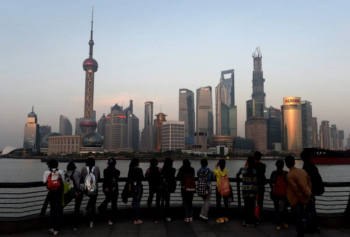 Tourists watch the sunset over the Pudong financial district of Shanghai on April 15. China’s economic growth slowed to 7.7 percent in the first quarter, data showed, below expectations and fuelling concerns that a recent recovery is faltering on subdued overseas demand. (Mark Ralston/Getty Images)