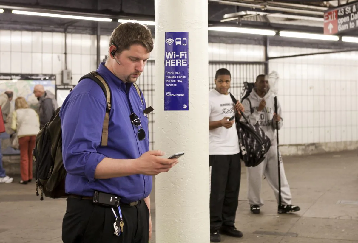 A commuter uses his smartphone in the newly wired Times Square subway platform on April 25. Times Square, one of the largest subways stations in the MTA system proved particularly challenging to wire. (Samira Bouaou/Epoch Times)
