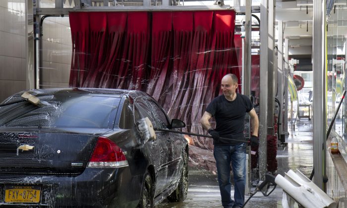 A worker, seen washing a car at Jomar Car Wash in Flushing, joined his colleagues to vote in favor of unionizing on April 24. Jomar Car Wash is the sixth car wash to unionize since Sept. 2012. (Samira Bouaou/Epoch Times)
