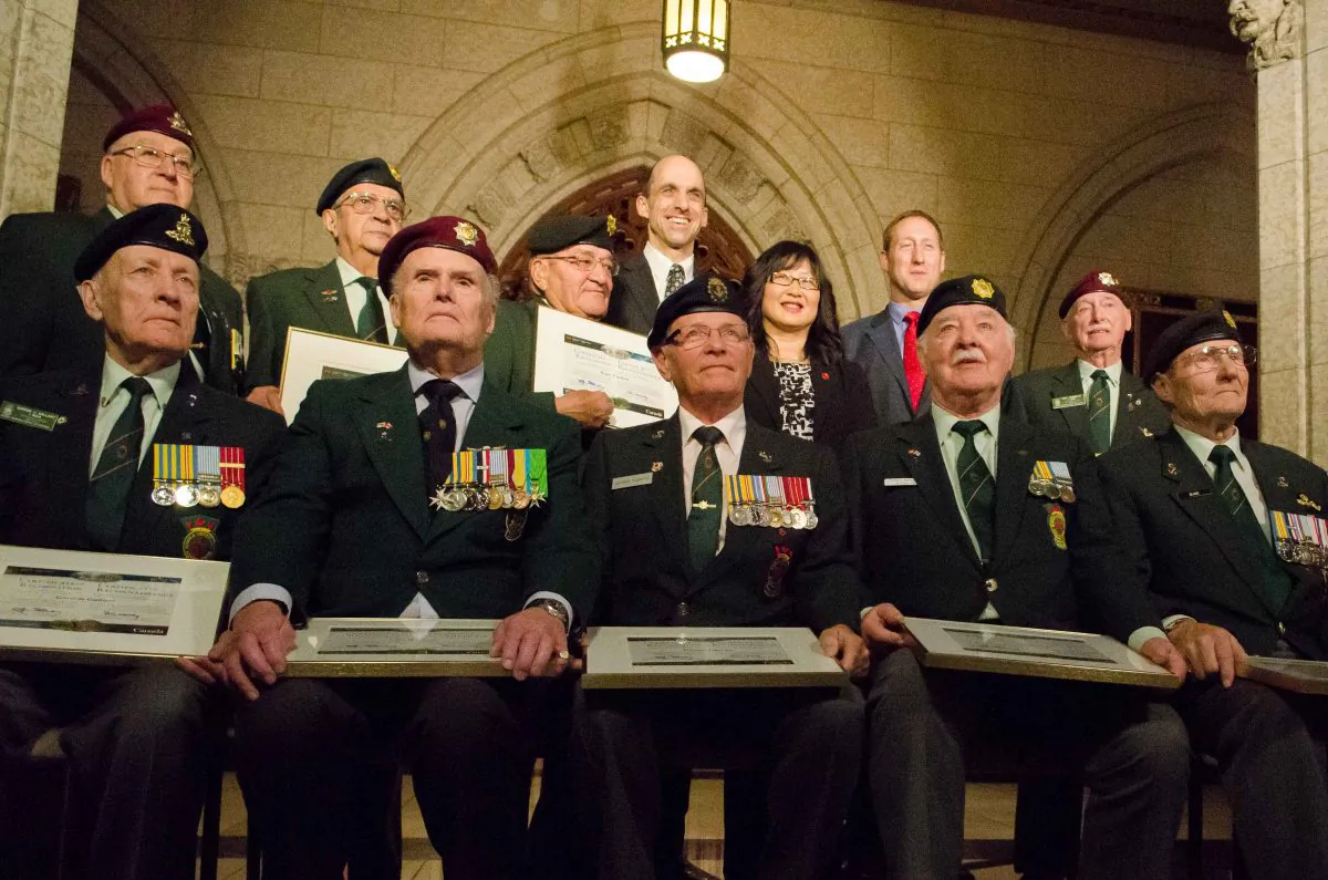 (Last row, L-R) Veterans Affairs Minister Stephen Blaney, Senator Yonah Martin, and Defence Minister Peter MacKay stand behind members of the Ottawa chapter of the Korea Veterans Association honoured for their sacrifice in the Korean War. (Matthew Little/The Epoch Times)
