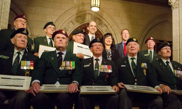 (Last row, L-R) Veterans Affairs Minister Stephen Blaney, Senator Yonah Martin, and Defence Minister Peter MacKay stand behind members of the Ottawa chapter of the Korea Veterans Association honoured for their sacrifice in the Korean War. (Matthew Little/The Epoch Times)