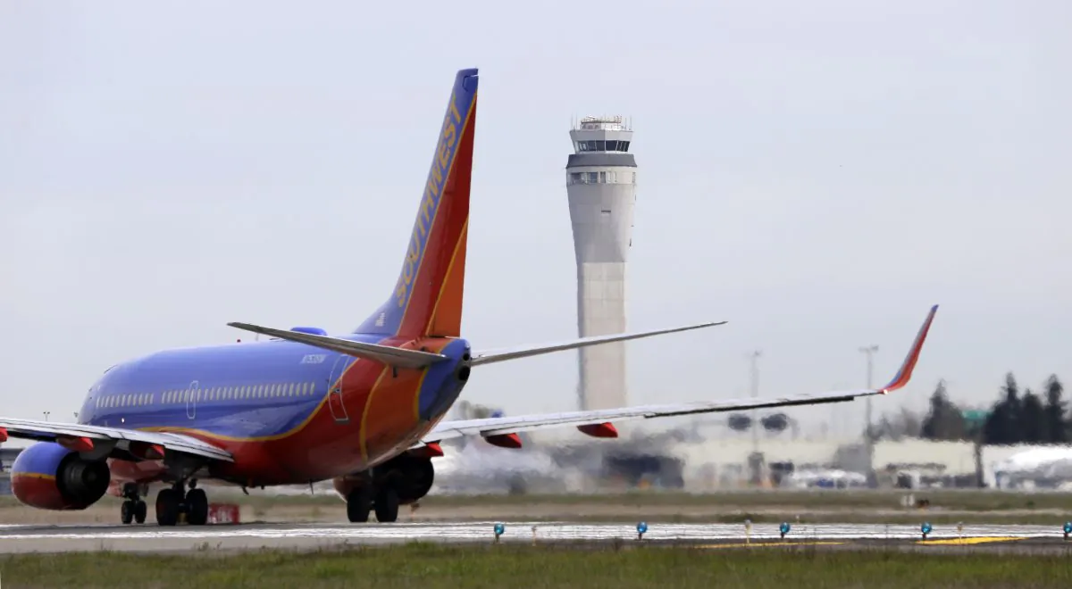 This photo taken April 23, 2013 shows a Southwest airlines jet waiting to depart in view of the air traffic control tower at Seattle-Tacoma International Airport in Seattle. (AP Photo/Elaine Thompson)