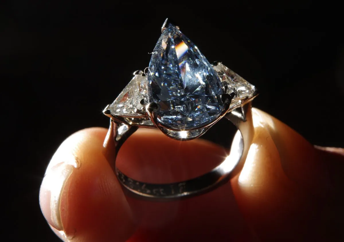 An employee displays a 5.16 carat pear shaped fancy vivid blue diamond ring at Sotheby's on March 8, 2010 in London, England. (Peter Macdiarmid/Getty Images)