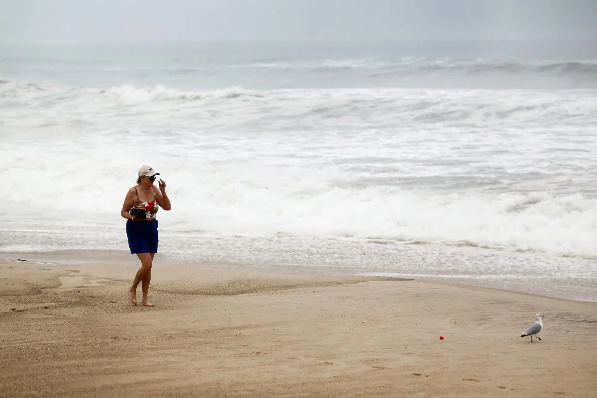 Christine Smith walks along the beach next to rough surf caused by the outer fringes of Hurricane Irene on August 27, 2011 in Water Mill, New York. This year is expected to be an active hurricane season. (Joe Raedle/Getty Images)