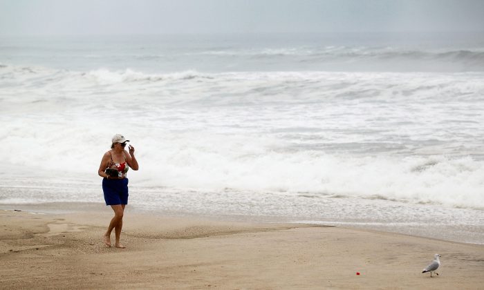 Christine Smith walks along the beach next to rough surf caused by the outer fringes of Hurricane Irene on August 27, 2011 in Water Mill, New York. This year is expected to be an active hurricane season. (Joe Raedle/Getty Images)