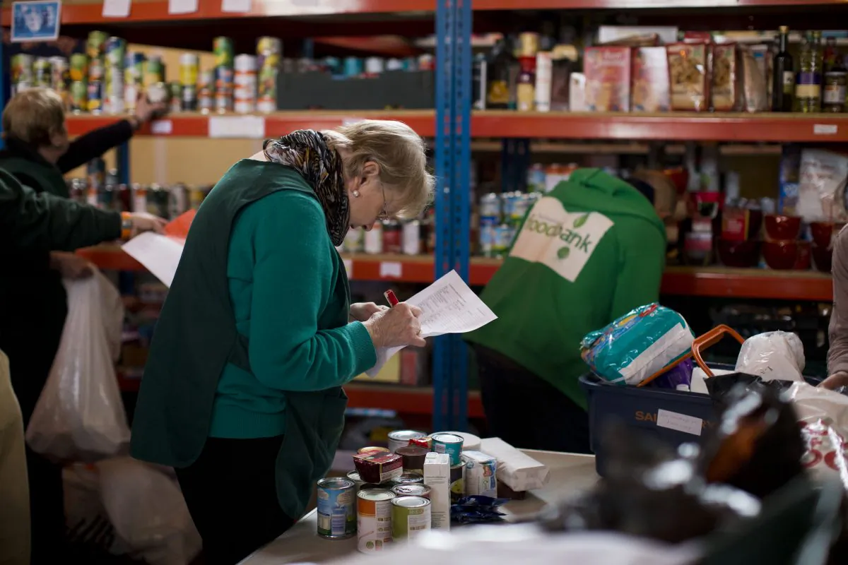 Volunteer Margaret Tobin checks items off a list of food to give out at a food bank in St Luke's Church in the West Norwood area of London, England, on April 5, 2013. (AP Photo/Matt Dunham)