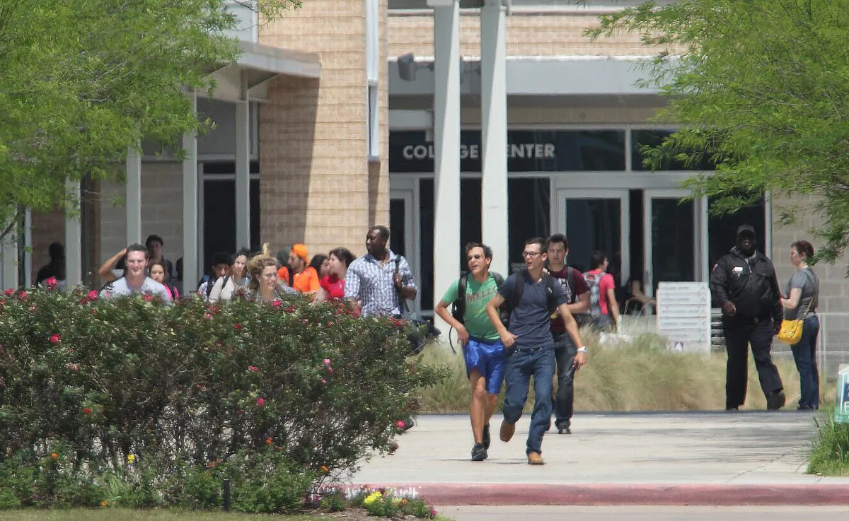 Students run from the Lone Star College's Cypress-Fairbanks campus Tuesday, April 9, 2013, in Cypress, Texas. At least 14 people were hurt in a stabbing at the campus.  (AP Photo/Houston Chronicle, James Nielsen)