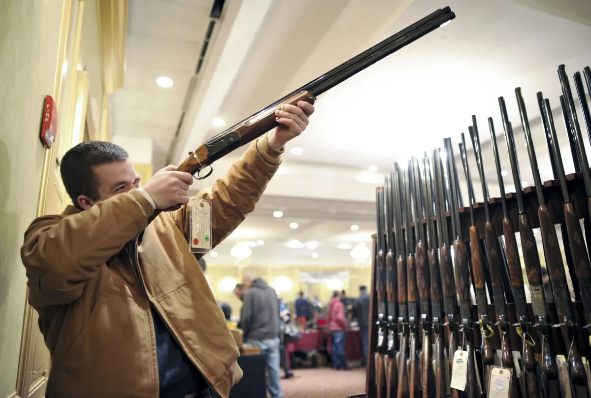 Collin McCarthy looks at a shotgun during a gun show in Stamford, Conn., Jan. 6. (Timothy A. Clary/AFP/Getty Images)