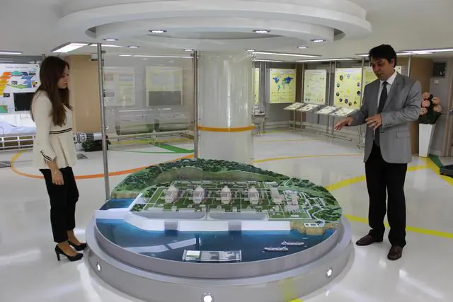 Information Center manager Faruk Uzel and a staff member of stand beside a model of the proposed power plant. (Hakan Kocman/Epoch Times).