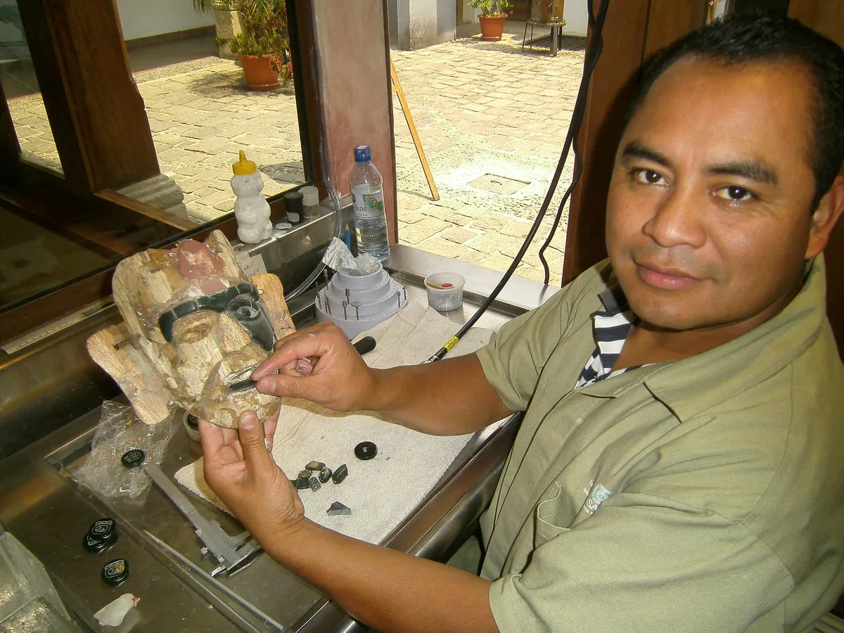 Pascual dePaz inserting sized and polished jade into replica Mayan mask. When completed the mask, on a hand carved wooden frame, will have 103 individual pieces and authentically replicate jade masks found in ancient tombs . (Myriam Moran copyright 2012)