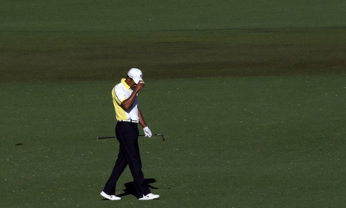 Tiger Woods reacts after his fairway shot on the 15th hole hit the pin and rolled into the water during the second round of the Masters golf tournament Friday, April 12, 2013, in Augusta, Ga. (AP Photo/Charlie Riedel)