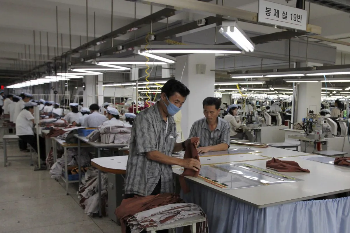 Two North Korean men working for ShinWon, a South Korean clothing maker, prepare garments for production at a factory in Kaesong, North Korea in 2012. North Korea shut down the Kaesong industrial complex April 8, after weeks of threats and mounting tension. (AP Photo/Jean H. Lee, File)