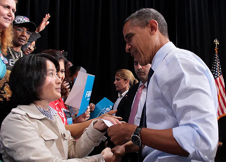 Karen Gao, from the Washington D.C. Falun Dafa Association, shakes hands with President Obama, and gives him a letter at a public campaign event at George Mason University in Fairfax, Va., on Oct. 5. The letter updates the president about the live, forced organ harvesting from Falun Gong practitioners by the Chinese Communist regime, and asks him to help end this atrocity. (The Epoch Times)