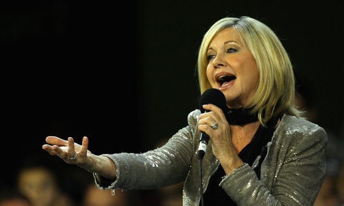 Olivia Newton John performs before a match between the Melbourne Demons and the Carlton Blues at the Melbourne Cricket Ground on May 27, 2011, in Melbourne, Australia. (Quinn Rooney/Getty Images)