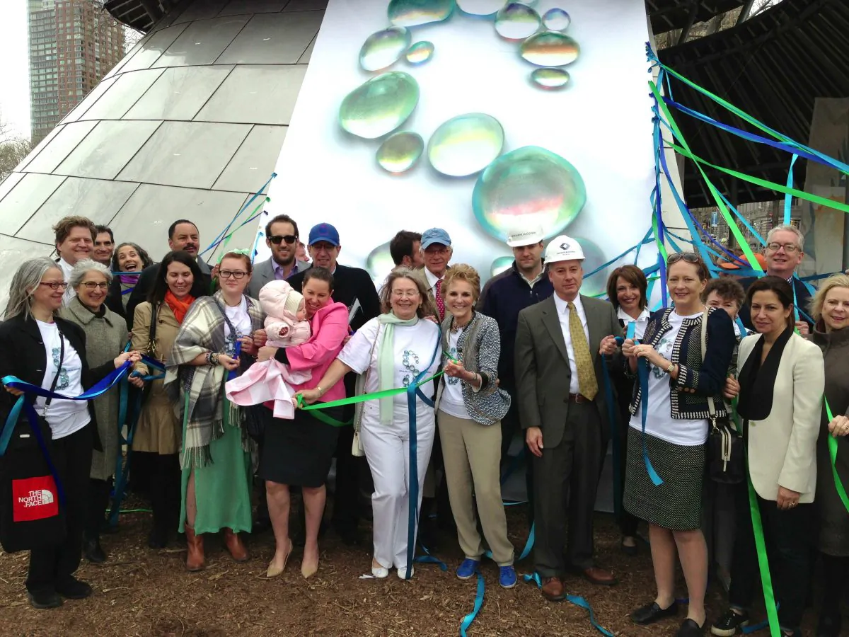 The people who made the SeaGlass Carousel possible pose for a photo before unveiling the last panel of the steel structure. (Ivan Pentchoukov/Epoch Times)