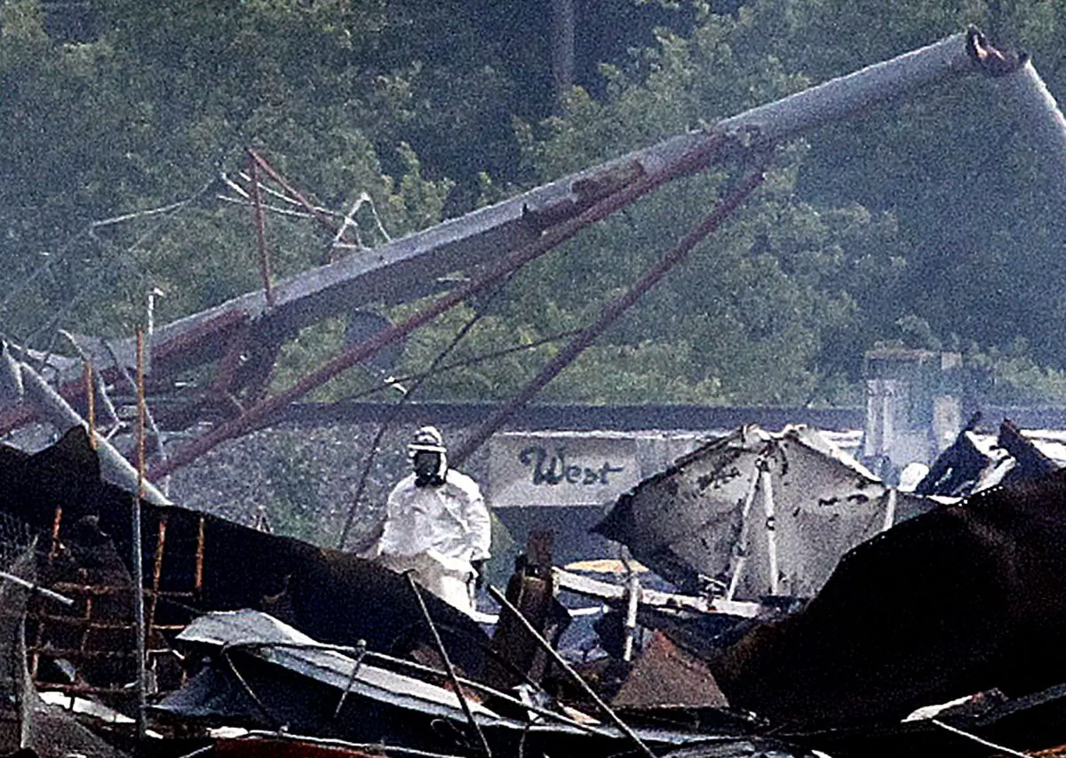 A searcher in a protective suit walks through the blast zone of the fertilizer plant that exploded Wednesday night in West, Texas Thursday April 18, 2013. (AP Photo/The Fort Worth Star-Telegram, Ron Jenkins)