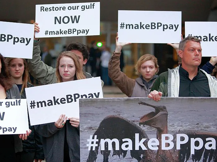 Activists hold signs in front of the Hale Boggs Federal Building in New Orleans on Feb. 25, the first day of the trial over the 2010 Deepwater Horizon oil rig disaster. On April 3, a federal judge dismissed claims against Cameron International, the company that sold the blowout preventer to BP and Transocean. (Sean Gardner/Getty Images)