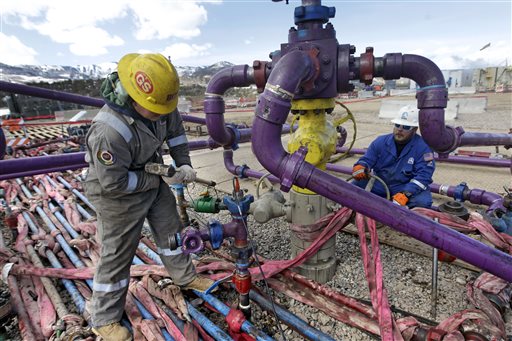 Workers tend to a well head during a hydraulic fracturing operation at an Encana Oil & Gas (USA) Inc. gas well outside Rifle, in western Colorado. (AP Photo/Brennan Linsley) 